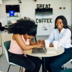 Two women laughing together at work, engaged and connected